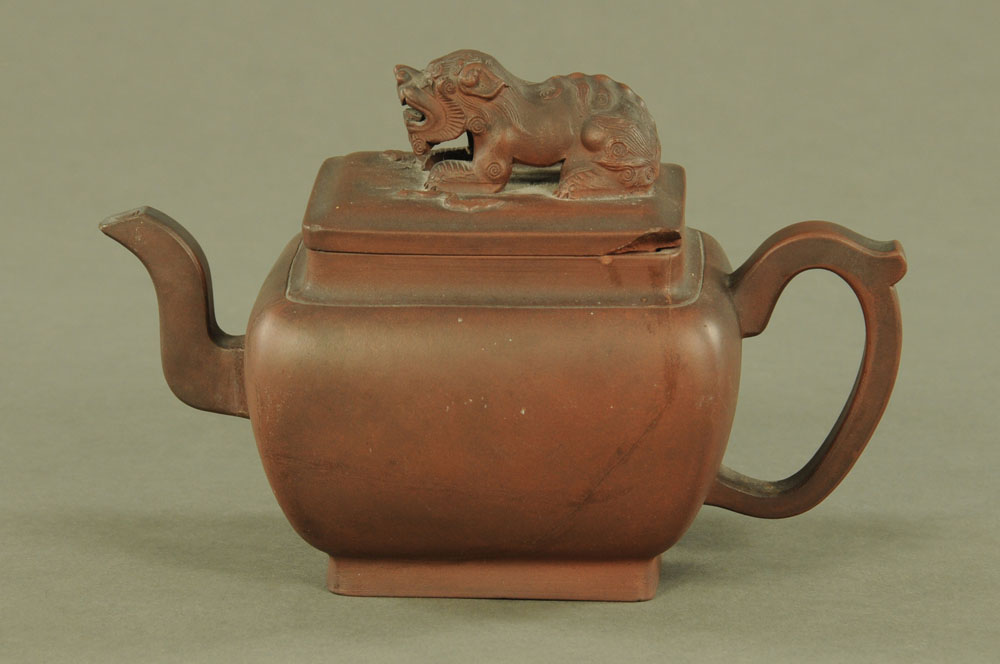 A Chinese Yixing teapot, with dog terminal. Height 14 cm, length 22 cm.