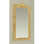 A composition and gilt painted wooden framed rectangular bevelled glass mirror,