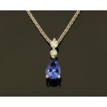 An 18 ct white gold pendant on chain, set with a pear shaped tanzanite and diamonds,