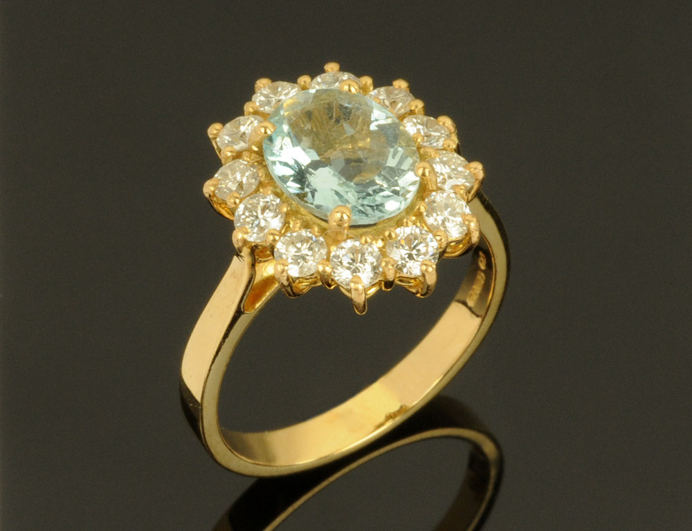 An 18 ct gold aquamarine and diamond cluster ring, aquamarine +/- 1.63 carats, diamonds +/- 0.