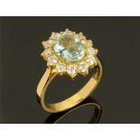 An 18 ct gold aquamarine and diamond cluster ring, aquamarine +/- 1.63 carats, diamonds +/- 0.