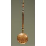 An early 19th century copper bed warming pan, with turned handle. Length 100 cm.