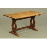 An oak refectory table, the rectangular top with moulded edge with silhouette end supports.