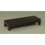 A 19th century Chinese hardwood low table, with moulded edge, recessed frieze and short legs.