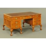 A Queen Anne style walnut desk, with brown tooled leather writing surface,