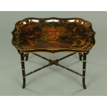 A Victorian papier mache painted tray housed in a later gilt and black painted table frame.