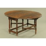 An antique oak twin drop flap gate legged dining table,
