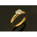 An 18 ct two tone gold ring, semi rubover set with an old cut diamond weighing +/- 0.73 ct. Size M.