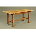 An oak Arts and Crafts refectory table, with slab end supports, centre stretcher and sledge feet.