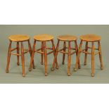 Four 19th century bar stools, each with angled turned legs and stretcher.