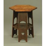 An oak Arts and Crafts hexagonal occasional table with angled pierced supports and low shelf.