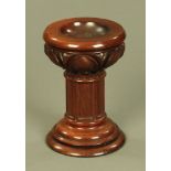 A Victorian mahogany font, with dished top and carved capital, raised on a stepped base.