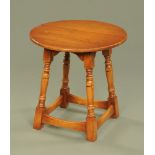 A Chapmans Siesta circular oak occasional table, raised on four angled legs with stretchers.