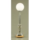 An Art Deco Gothic style chrome plated table lamp, with milk glass shade. Overall height 86 cm.