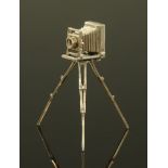 A miniature silver model of a vintage camera on tripod stand, stamped 925. Height 9 cm.