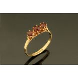 A 9 ct gold three stone garnet ring, Size M.