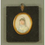 A 19th century portrait miniature, an elderly lady wearing a white and blue smock.