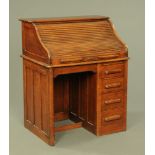 A small oak roll top desk, with fitted interior and with drawers to the pedestal.