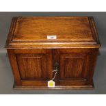 A late 19th/early 20th century oak smokers compendium, with lift up lid and hinged doors,