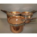 A set of three 19th century copper and steel handled saucepans with lids (slight denting and wear).