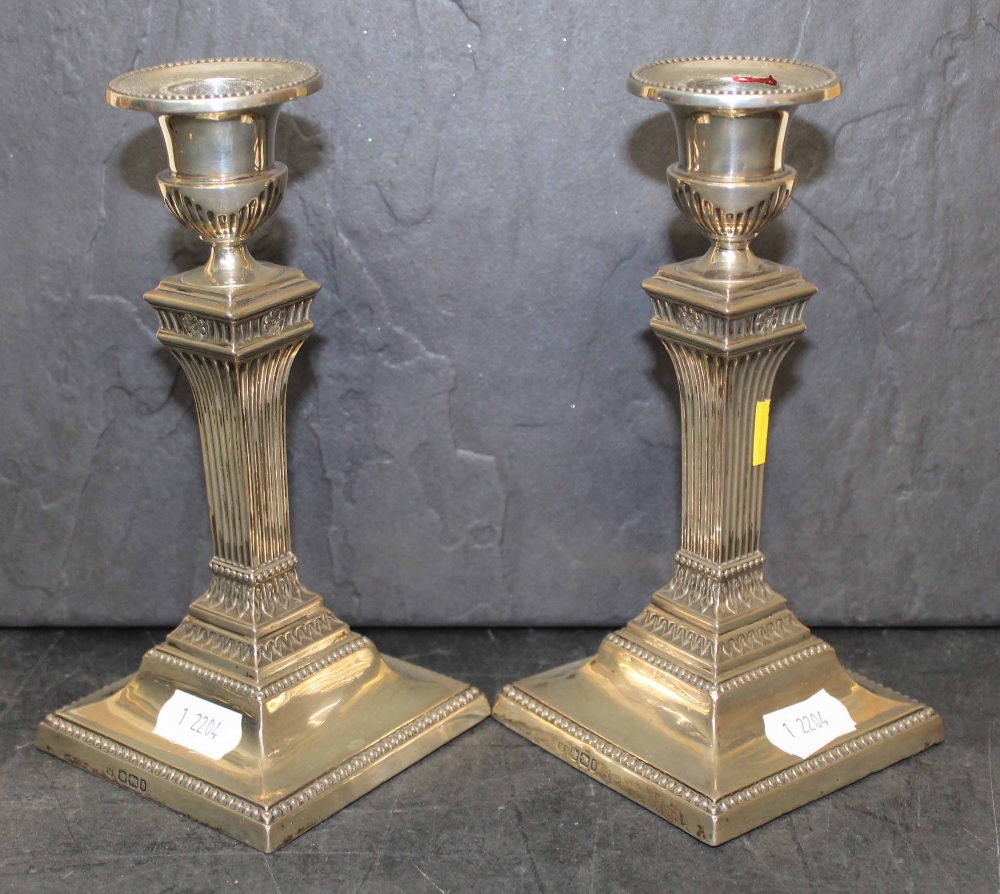 A pair of late Victorian silver pillar candlesticks of reeded column design on square bases, - Image 2 of 2