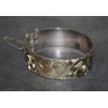 An Elizabeth II silver hinged stiff bracelet engraved with leaf scrolls, Birmingham 1974,