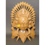 A Balinese carved light wood bust, of a female deity with ornate head dress,