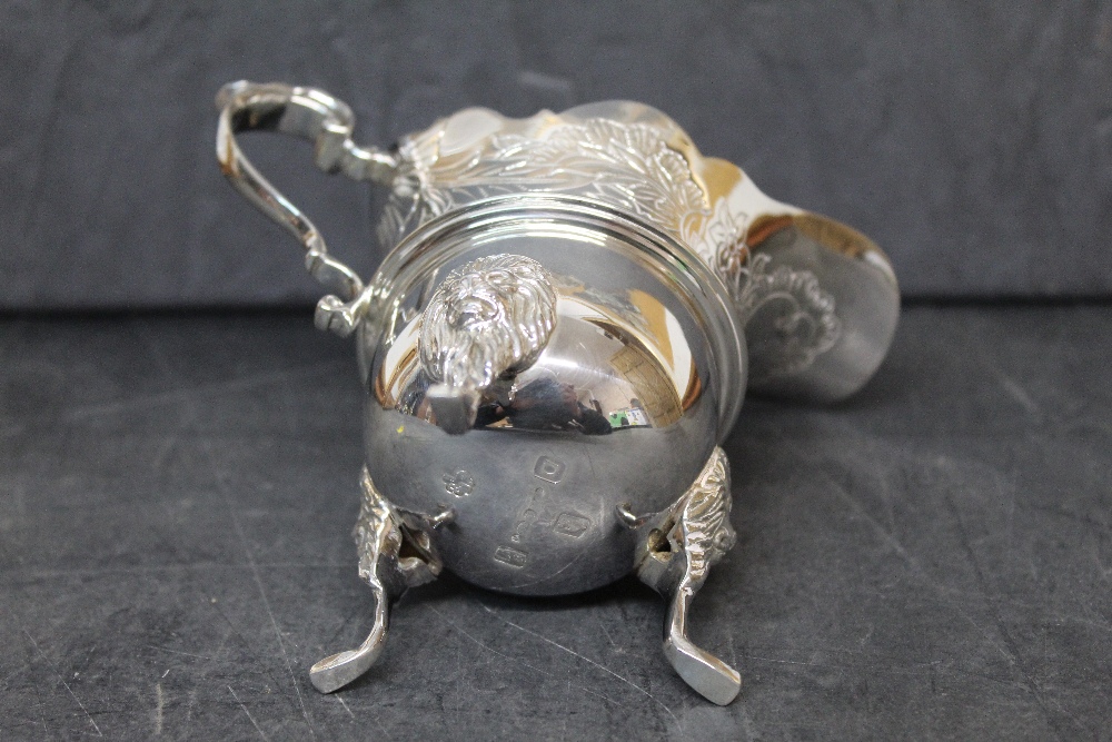 An Elizabeth II silver cream jug of George II design with pronounced spout, engraved with leaves, - Image 2 of 2