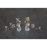 A pair of amethyst and white metal stud earrings with baguette cut stones and three other pairs of