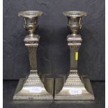 A pair of late Victorian silver pillar candlesticks of reeded column design on square bases,