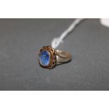 A gold coloured metal and blue stone ring, the pale blue oval stone approximately 1 cart,