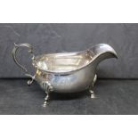 A George V silver sauce boat with beaded rim and three paw feet, by Edward Souter Barnsley, 15.