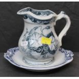 A 19th century blue and white pottery jug, transfer printed with flowers, 15 cm high,