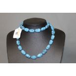 A blue hard stone graduated bead necklace with gilt metal screw clasp,