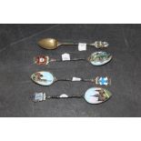 Four early 20th century continental white metal and enamelled souvenir teaspoons respectively for