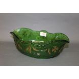 An oval green pressed glass bowl, with gilt enriched decoration,