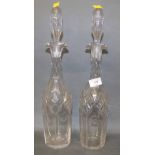 A pair of tall cut glass decanters with elongated faceted stoppers,