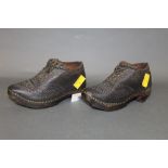 A pair of child's leather and wood clogs, with embossed and studded leather work,