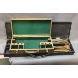 Two shooting related cases, one in light oak, opening to a green baize lined fitted interior,