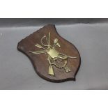 An oak plaque mounted with a brass flintlock sporting gun, a fishing net, riding crop, hunting horn,