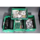 Four green plastic stacking trays filled with fly tying hooks, various sizes,