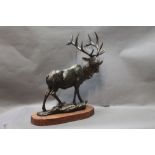 A modern cast iron figure of a North American elk, mounted on a wooden plinth. Height 47 cm.