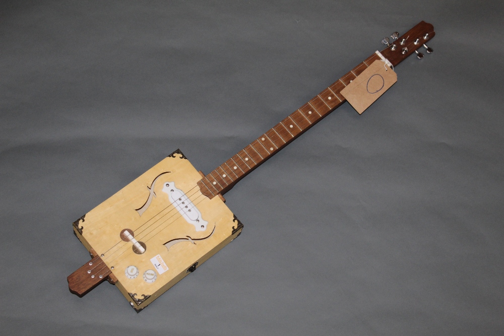 A hand built cigar box electric guitar, 95 cm long with stand for same.