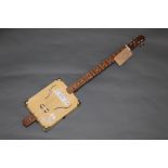 A hand built cigar box electric guitar, 95 cm long with stand for same.