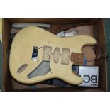 A box of assorted musical items including a cream lacquered guitar body, switches etc.