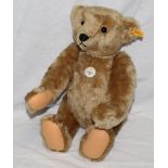 A Steiff Classic 1906 replica teddy bear, having a beige mohair covered body, with felt paw pads,