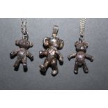 Three teddy bear pendants, two with chains.