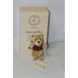 A Steiff 75th Anniversary "Winnie The Pooh" teddy bear, having a blonde mohair plush body,