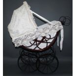 A Victorian style pram, having four spoked metal wheels, a detachable wicker basket and canopy,