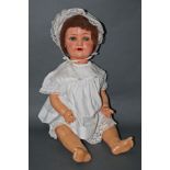 An early 20th century Schoenau and Hoffmeister composition doll, 170-6, having sleep eyes,